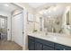 Bathroom featuring a blue vanity, a large mirror and a walk-in shower at 923 Fairwaycove Ln # 103, Bradenton, FL 34212