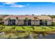 Exterior view of a condo building, with landscaped lawn and lake at 923 Fairwaycove Ln # 103, Bradenton, FL 34212