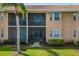 Exterior view of screened-in patios overlooking manicured backyard with verdant lawn and tropical palm trees at 923 Fairwaycove Ln # 103, Bradenton, FL 34212