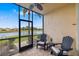 Screened in lanai with two black chairs, table and view of the pond at 923 Fairwaycove Ln # 103, Bradenton, FL 34212