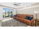 Bright living room featuring a plush leather sofa, stylish zebra rug and sliding door to the lanai at 923 Fairwaycove Ln # 103, Bradenton, FL 34212
