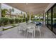 Elegant outdoor dining area with a spacious table, white chairs, and a view of the pool at 112 Elm Ave, Anna Maria, FL 34216