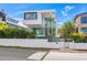 Modern, white two-story home with a wall, tropical landscaping and floor-to-ceiling windows at 115 N Bay Blvd, Anna Maria, FL 34216