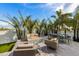 Beautiful patio area featuring comfortable seating around a modern fire pit and a dining table perfect for outdoor entertaining at 115 N Bay Blvd, Anna Maria, FL 34216