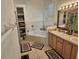 Bright bathroom features soaking tub, double sinks, and cabinet with shelving for linen storage at 1155 Millbrook Cir, Bradenton, FL 34212