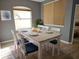 Bright dining room featuring a wood table, white chairs with blue cushions, and lots of natural light at 1155 Millbrook Cir, Bradenton, FL 34212