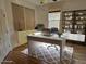 Bright home office with a modern white desk, stylish shelving unit, and a comfortable workspace setup at 1155 Millbrook Cir, Bradenton, FL 34212