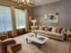 Cozy living room boasts plush seating, designer decor, neutral paint and lots of natural light at 1155 Millbrook Cir, Bradenton, FL 34212