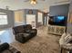 Cozy living room with a large TV, comfortable seating, and views into the adjacent bedroom at 1155 Millbrook Cir, Bradenton, FL 34212