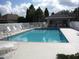 Community pool enclosed by a white fence, offering lounge chairs and a covered seating area for relaxation at 1155 Millbrook Cir, Bradenton, FL 34212