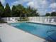 Sparkling in-ground pool with a white fence and lounge chairs, perfect for relaxing and enjoying the outdoors at 1155 Millbrook Cir, Bradenton, FL 34212