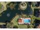 Aerial shot of the community pool surrounded by lush landscaping and a pond at 1318 3Rd Street E Cir, Palmetto, FL 34221
