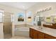 Bright bathroom featuring dual vanity sinks, a glass shower, and a luxurious soaking tub at 1318 3Rd Street E Cir, Palmetto, FL 34221