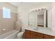Well-lit bathroom featuring tiled walls, a shower and tub, plus a large mirror and vanity at 1318 3Rd Street E Cir, Palmetto, FL 34221