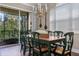 Elegant dining room featuring a chandelier, sliding glass doors to a balcony, and plantation shutters at 1318 3Rd Street E Cir, Palmetto, FL 34221