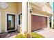 Close-up of a front door and garage with brick paving and garden space at 1318 3Rd Street E Cir, Palmetto, FL 34221