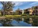 Beautiful Florida condos reflected in a pond, surrounded by lush greenery and mature oak trees at 1318 3Rd Street E Cir, Palmetto, FL 34221