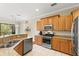 Modern kitchen with stainless steel appliances, granite countertops, and wood cabinetry at 1318 3Rd Street E Cir, Palmetto, FL 34221