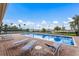 Outdoor pool area with lounge chairs and beautiful views of the tennis court at 1318 3Rd Street E Cir, Palmetto, FL 34221