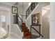 Elegant staircase with wood steps, black railing, and decorative wall art at 1318 3Rd Street E Cir, Palmetto, FL 34221