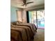 Bedroom with a pool view through sliding glass doors, two beds, and neutral colored walls at 1428 Pine Island Ct, Punta Gorda, FL 33950