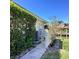 Exterior shot of home with a narrow pathway, lush landscaping and a bright blue sky at 1428 Pine Island Ct, Punta Gorda, FL 33950