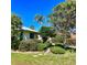 Beautifully landscaped front yard with mature trees, shrubs, and stone pathway to the house at 1428 Pine Island Ct, Punta Gorda, FL 33950