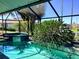 Screened-in pool area with a jacuzzi, tropical plants, and a beautiful blue swimming pool at 1428 Pine Island Ct, Punta Gorda, FL 33950