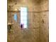 Tiled shower with glass door, chrome fixtures, shower caddy, and a view to the outside through a window at 1428 Pine Island Ct, Punta Gorda, FL 33950