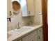 Bathroom sink with tiled countertop, white cabinets, and a wall mounted woven plate at 1428 Pine Island Ct, Punta Gorda, FL 33950