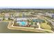Beautiful aerial of community amenities showcasing pool, tennis courts, clubhouse, parking, and surrounding homes near a serene lake at 1524 Remington Trace Dr, Port Charlotte, FL 33953