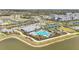 Community amenities aerial showcasing pool, tennis courts, clubhouse, parking, and proximity to lake at 1524 Remington Trace Dr, Port Charlotte, FL 33953