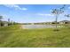 Lush green backyard with a serene lake and fountain feature at 1524 Remington Trace Dr, Port Charlotte, FL 33953