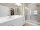 Bathroom featuring double sinks, a large mirror, and a glass-enclosed shower with tile surround at 1524 Remington Trace Dr, Port Charlotte, FL 33953