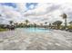 Resort-style community pool with plenty of lounge chairs and palm trees, perfect for a relaxing day in the sun at 1524 Remington Trace Dr, Port Charlotte, FL 33953