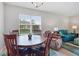 Cozy dining area with wooden table next to the living area filled with natural light at 1524 Remington Trace Dr, Port Charlotte, FL 33953