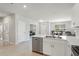 Modern kitchen with stainless steel dishwasher, sink, white cabinets and breakfast bar at 1524 Remington Trace Dr, Port Charlotte, FL 33953