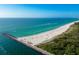Attractive aerial view of a beach with clear water, a breakwater, and lush greenery, ideal for a tranquil living at 1582 Overbrook Rd, Englewood, FL 34223