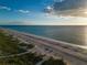 Serene aerial view of a sandy beach with clear water and grassy dunes, perfect for a nature retreat at 1582 Overbrook Rd, Englewood, FL 34223