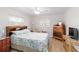 Well-lit bedroom featuring a charming bed, a large dresser, and a woven wicker TV stand at 1582 Overbrook Rd, Englewood, FL 34223