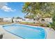 Inviting in-ground pool surrounded by a concrete deck and lush landscaping in a fenced backyard at 1582 Overbrook Rd, Englewood, FL 34223