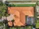 Overhead view of tile roof, screened-in pool, manicured lawn, and putting green for outdoor enjoyment at 1813 Boyce St, Sarasota, FL 34239