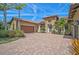 Exterior view of a house with a brick driveway, stone accents, a brown garage door, and landscaping at 1813 Boyce St, Sarasota, FL 34239