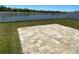 Landscaped backyard featuring a brick paver patio, lawn, and white vinyl fence at 1819 Redmond Brook Ln, Ruskin, FL 33570