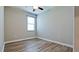 Sunny bedroom featuring wood floors, a ceiling fan, and a large window at 1819 Redmond Brook Ln, Ruskin, FL 33570