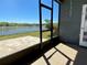 Screened patio with a view of backyard with water view, white fence, and lawn at 1819 Redmond Brook Ln, Ruskin, FL 33570