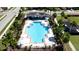 Aerial shot of community pool and clubhouse surrounded by palm trees and lounge chairs at 1819 Redmond Brook Ln, Ruskin, FL 33570