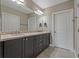 Main bathroom with double sinks, granite countertop and vanity with dark cabinetry at 23085 Banbury Way # 103, Venice, FL 34293