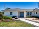 Welcoming home exterior featuring a blue double-door entrance, neat landscaping, and a well-kept lawn at 2466 Breakwater Cir, Sarasota, FL 34231