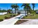 Well-kept house with a long driveway, lush lawn, and tropical palm trees at 2466 Breakwater Cir, Sarasota, FL 34231